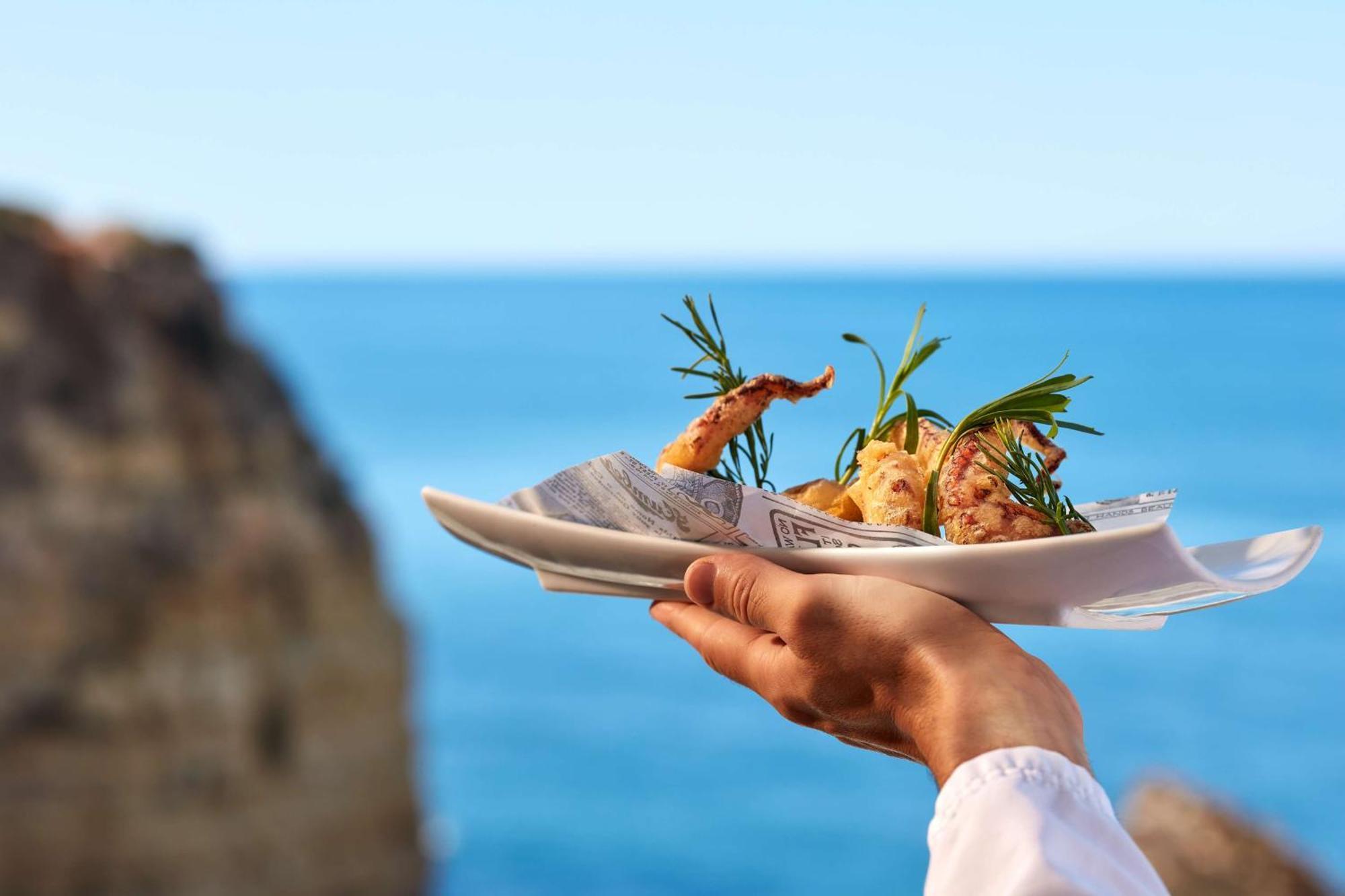 Tivoli Carvoeiro Hotel Carvoeiro  Ngoại thất bức ảnh A waiter holding a plate of food